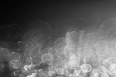 koyu arka plan üzerinde beyaz parlama bokeh ışıklar, sihir efekti yerleşimi.  