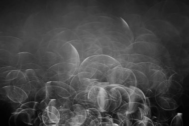 koyu arka plan üzerinde beyaz parlama bokeh ışıklar, sihir efekti yerleşimi.  