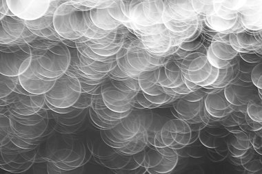 koyu arka plan üzerinde beyaz parlama bokeh ışıklar, sihir efekti yerleşimi.  