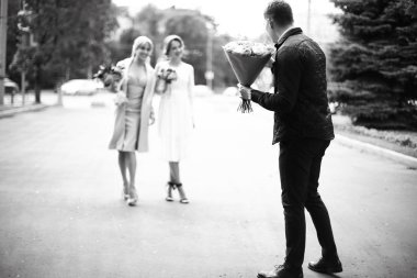 Neşeli konukları düğün, bir buket çiçek, siyah ve beyaz holding takım elbiseli adam arkadan görünüm 