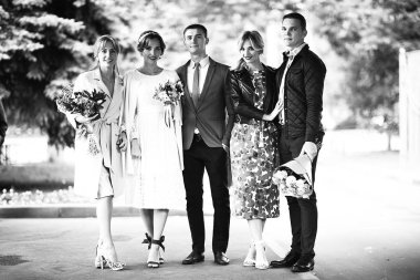 güzel genç nedime, mutlu gelin ve Damat Düğün gününde, siyah ve beyaz parkta poz 