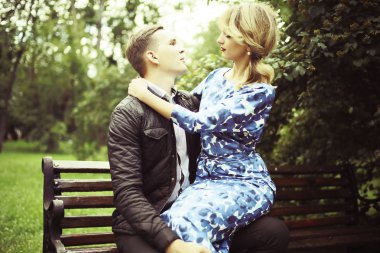 güzel genç kadın ve yaz parkta bankta oturan yakışıklı adam. Çift tarihte açık tr 