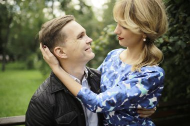 güzel genç kadın ve yaz parkta bankta oturan yakışıklı adam. Çift tarihte açık tr 