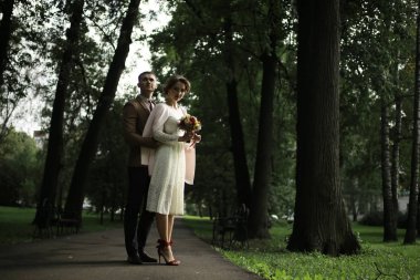 Beyaz elbise ve yakışıklı Damat Düğün gününde yaz parkta poz güzel genç gelin 