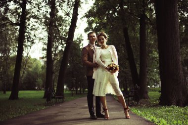 Beyaz elbise ve yakışıklı Damat Düğün gününde yaz parkta poz güzel genç gelin 