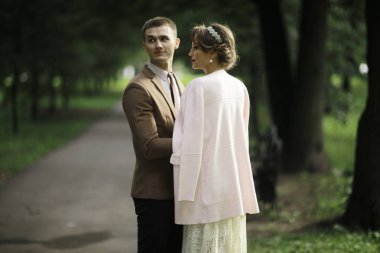 Beyaz elbise ve yakışıklı Damat Düğün gününde yaz parkta poz güzel genç gelin 