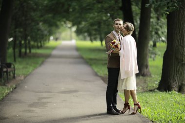 Beyaz elbise ve yakışıklı Damat Düğün gününde yaz parkta poz güzel genç gelin 