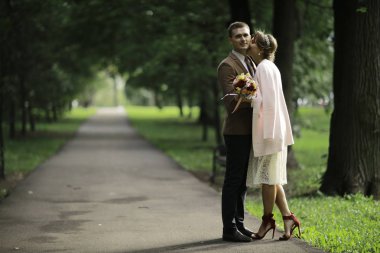 Beyaz elbise ve yakışıklı Damat Düğün gününde yaz parkta poz güzel genç gelin 