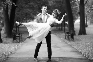 Beyaz elbise ve yakışıklı Damat Düğün gününde, siyah ve beyaz yaz parkta poz güzel genç gelin 