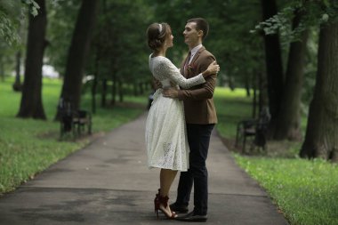 Beyaz elbise ve yakışıklı Damat Düğün gününde yaz parkta poz güzel genç gelin 