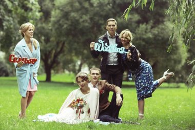 güzel genç nedime, mutlu gelin ve Damat Düğün gününde yaz parkta eğleniyor 