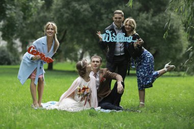 güzel genç nedime, mutlu gelin ve Damat Düğün gününde yaz parkta eğleniyor 