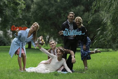 güzel genç nedime, mutlu gelin ve Damat Düğün gününde yaz parkta eğleniyor 