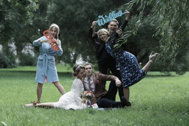 güzel genç nedime, mutlu gelin ve Damat Düğün gününde yaz parkta eğleniyor 