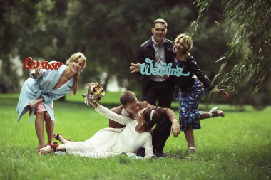 güzel genç nedime, mutlu gelin ve Damat Düğün gününde yaz parkta eğleniyor 