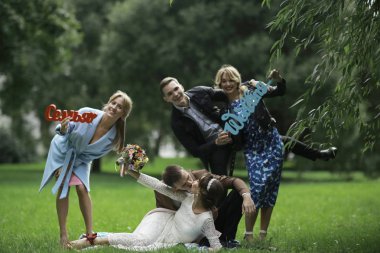 güzel genç nedime, mutlu gelin ve Damat Düğün gününde yaz parkta eğleniyor 