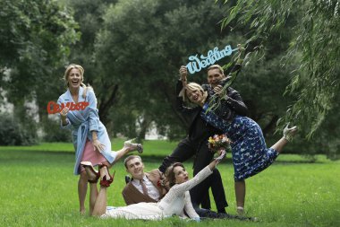 güzel genç nedime, mutlu gelin ve Damat Düğün gününde yaz parkta eğleniyor 