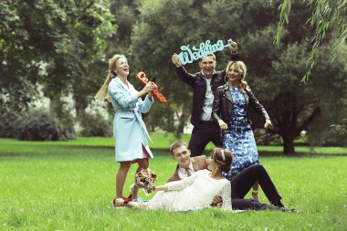 güzel genç nedime, mutlu gelin ve Damat Düğün gününde yaz parkta eğleniyor 