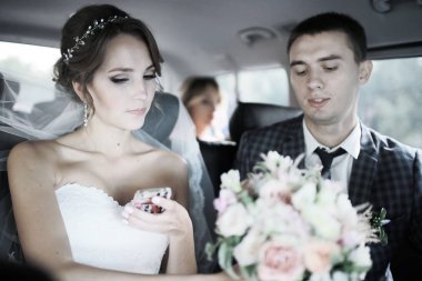 güzel genç gelin ve birlikte arabada oturan mutlu yakışıklı damat 