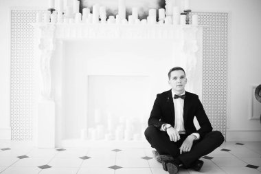 yakışıklı delikanlı papyon beyaz şömine mum ile zarif iç oturma ile 