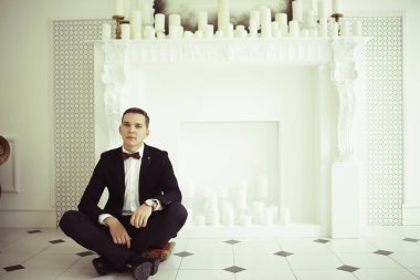 yakışıklı delikanlı papyon beyaz şömine mum ile zarif iç oturma ile 