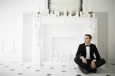 yakışıklı delikanlı papyon beyaz şömine mum ile zarif iç oturma ile 