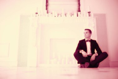 yakışıklı delikanlı papyon beyaz şömine mum ile zarif iç oturma ile 