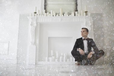 yakışıklı delikanlı papyon beyaz şömine mum ile zarif iç oturma ile 