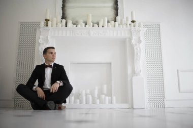 yakışıklı delikanlı papyon beyaz şömine mum ile zarif iç oturma ile 