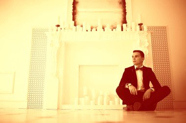 yakışıklı delikanlı papyon beyaz şömine mum ile zarif iç oturma ile 