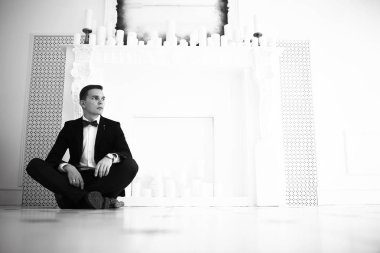 yakışıklı delikanlı papyon beyaz şömine mum ile zarif iç oturma ile 