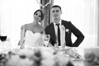 güzel genç gelin ve yakışıklı Damat Düğün gününde yemek masasında oturan 
