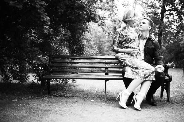 güzel genç kadın ve yakışıklı adam parkta bankta oturuyor. Çift tarihte tr açık, siyah ve beyaz 