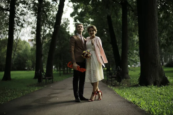 Beyaz elbise ve yakışıklı Damat Düğün gününde yaz parkta poz güzel genç gelin 