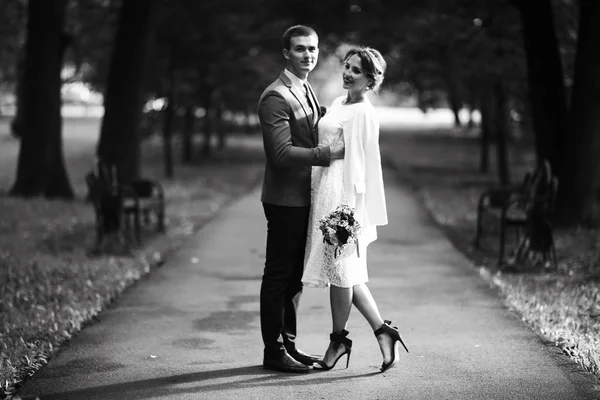 白いドレスとハンサムな新郎の結婚式の日 黒と白の夏の公園でポーズ美しい若い花嫁 — ストック写真