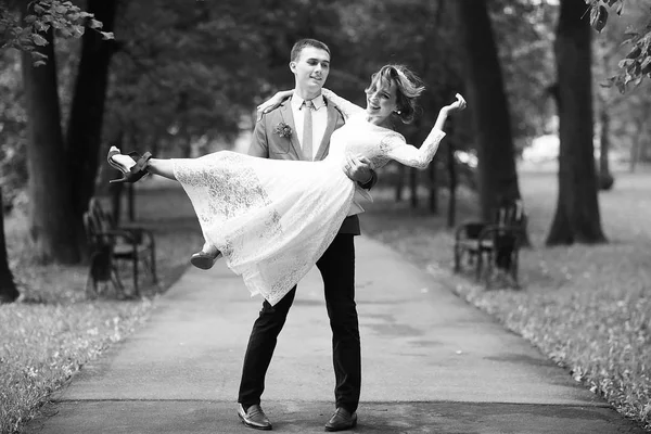 Beyaz elbise ve yakışıklı Damat Düğün gününde, siyah ve beyaz yaz parkta poz güzel genç gelin 