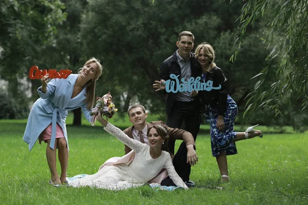 güzel genç nedime, mutlu gelin ve Damat Düğün gününde yaz parkta eğleniyor 