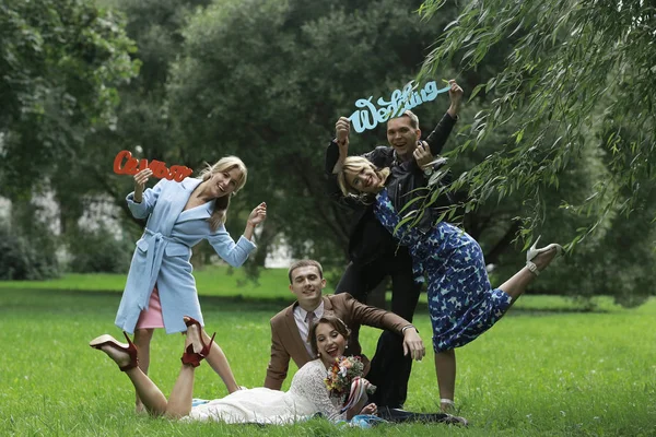 güzel genç nedime, mutlu gelin ve Damat Düğün gününde yaz parkta eğleniyor 
