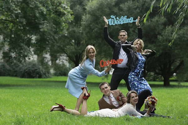 güzel genç nedime, mutlu gelin ve Damat Düğün gününde yaz parkta eğleniyor 