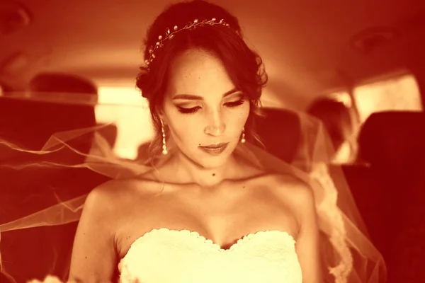 美丽年轻新娘的画像在婚礼白色礼服坐在汽车 — 图库照片