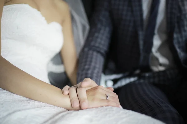 白のドレス 新郎新婦一緒に座っていると 結婚式の日に手を繋いでの若い花嫁 — ストック写真