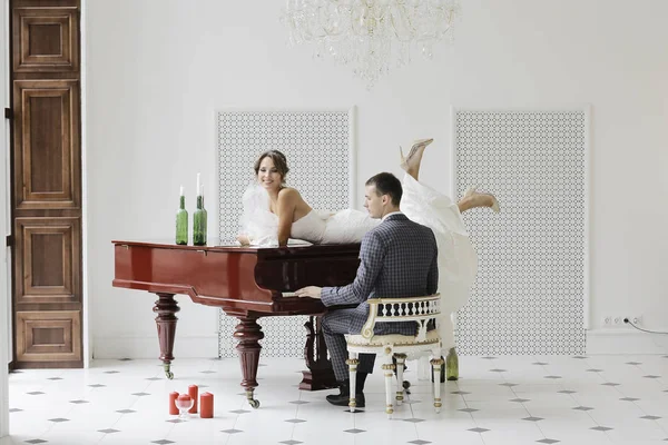 Noivo tocando piano de cauda e noiva — Fotografia de Stock