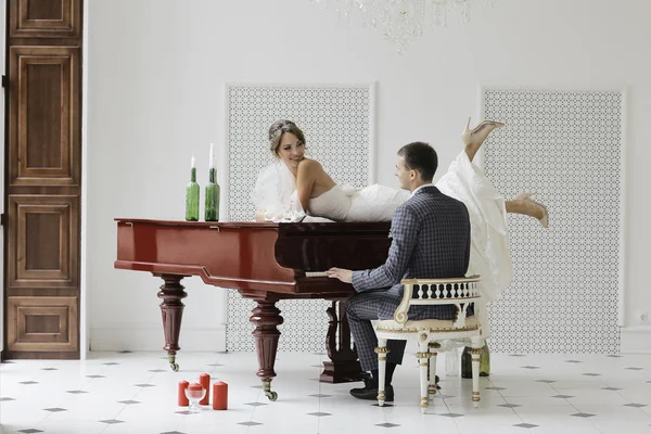 Novio tocando piano de cola y novia — Foto de Stock