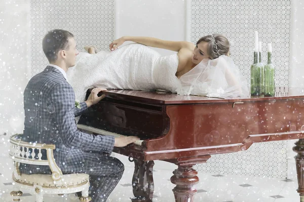 Brudgummen spelar flygel och bruden — Stockfoto