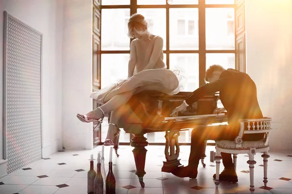 Uomo che suona il pianoforte a coda e donna — Foto Stock