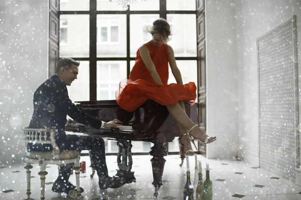 Uomo che suona il pianoforte a coda e donna — Foto Stock