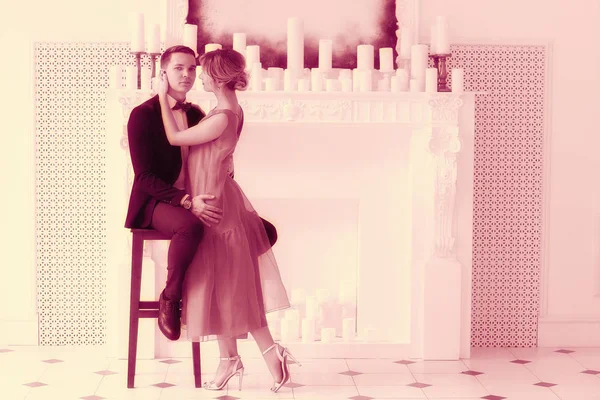 güzel genç kadın ve yakışıklı adam beyaz şömine mum, zarif iç ile yakın poz uygun 