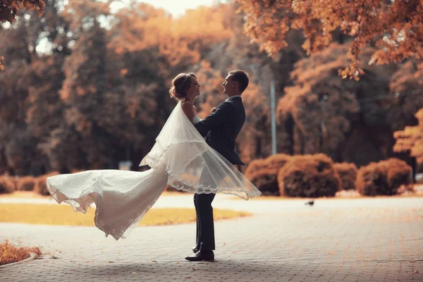 Bride and groom in autumn park — Stock Photo, Image