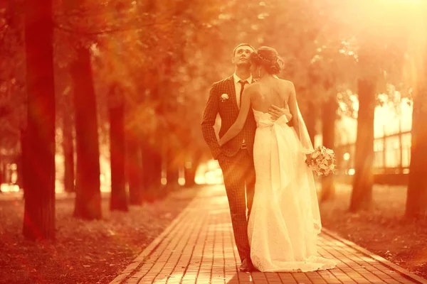 Bride and groom in autumn park — Stock Photo, Image