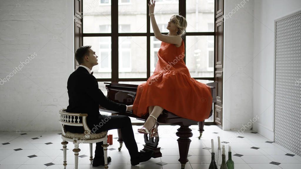 man playing grand piano and woman  